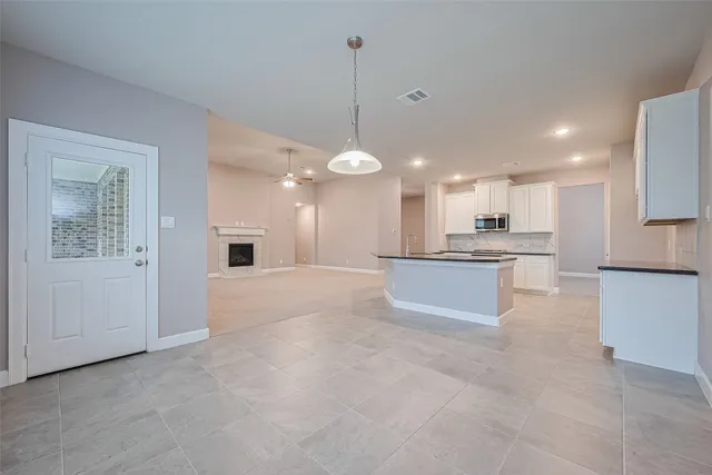 a large kitchen with a large counter top stainless steel appliances and a cabinets