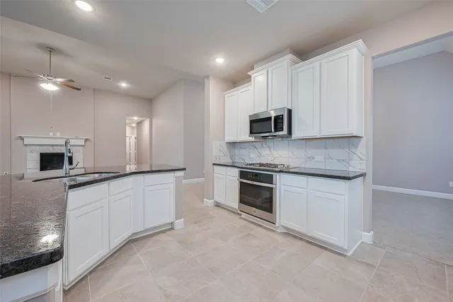 a kitchen with stainless steel appliances a refrigerator sink and white cabinets