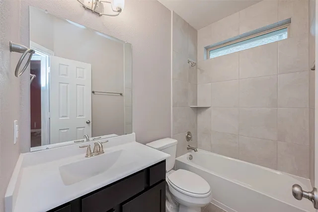 an empty room with chandelier fan and windows