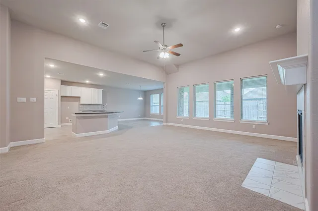 a view of an empty room with a fireplace and a window