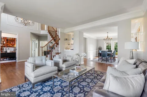 a living room with furniture a fireplace and a chandelier