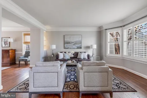 a living room with furniture and a large window with wooden floor