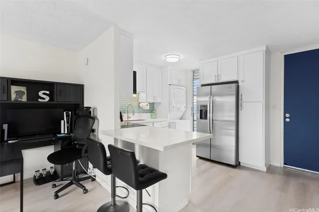 a view of a kitchen with kitchen island and stainless steel appliances