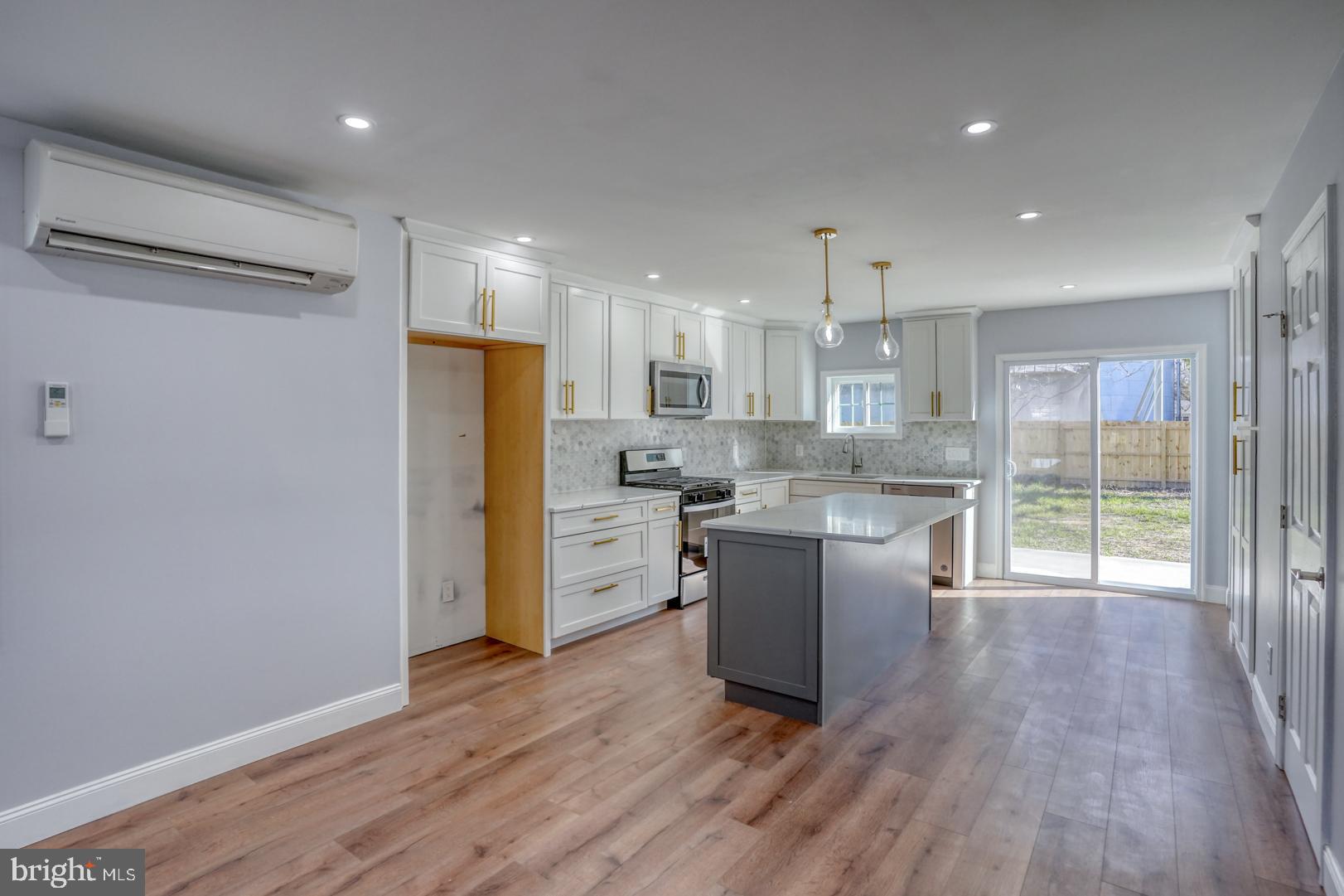 613 Taylor Street Townsend, DE 19734 - Photo 13 of 36 a kitchen with stainless steel appliances granite countertop a refrigerator a sink a stove and white cabinets with wooden floor
