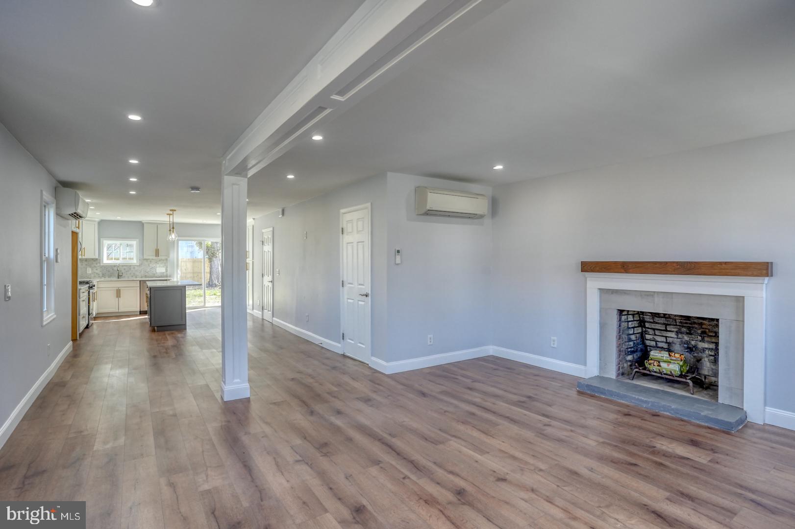 613 Taylor Street Townsend, DE 19734 - Photo 8 of 36 a view of kitchen and hall with wooden floor and a fireplace