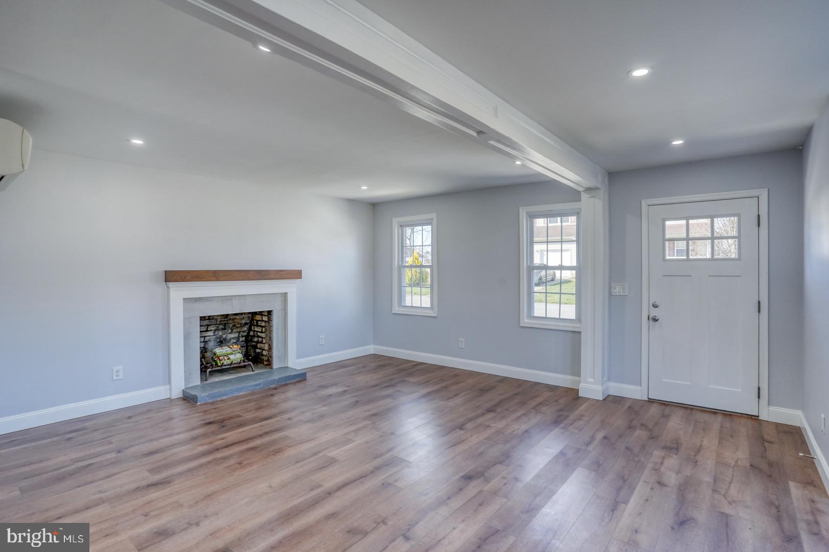 613 Taylor Street Townsend, DE 19734 - Photo 10 of 36 an empty room with wooden floor fireplace and windows