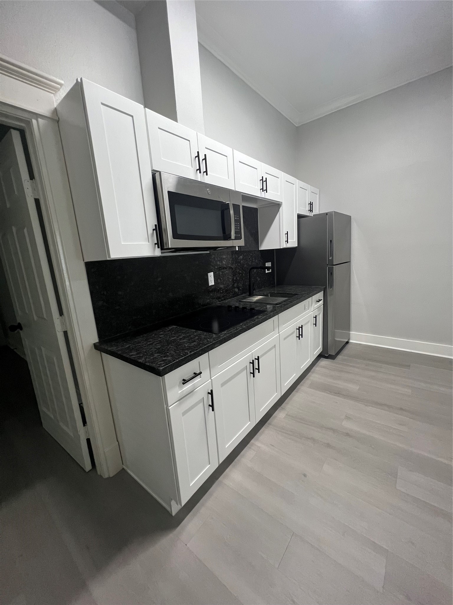 220 Redan Street, Unit A Houston, TX 77009 - Photo 8 of 22 a kitchen with stainless steel appliances a sink a microwave a stove and white cabinets