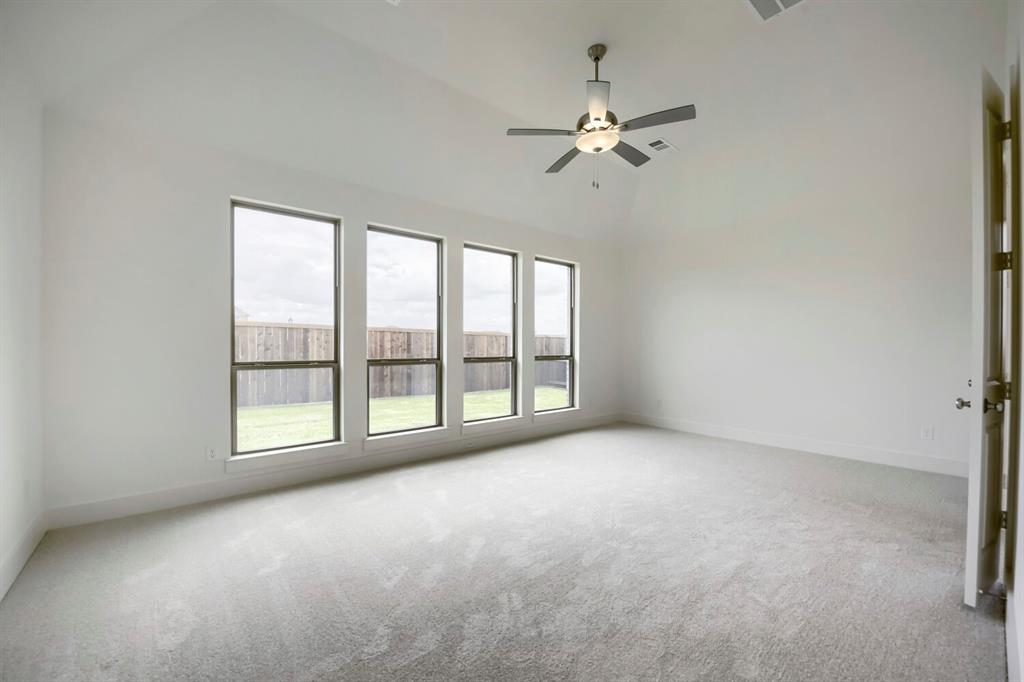 11548 Wulstone Road Haslet, TX 76052 - Photo 12 of 26 Spacious room featuring vaulted ceilings, a contemporary ceiling fan with integrated lighting, and plush grey carpeting