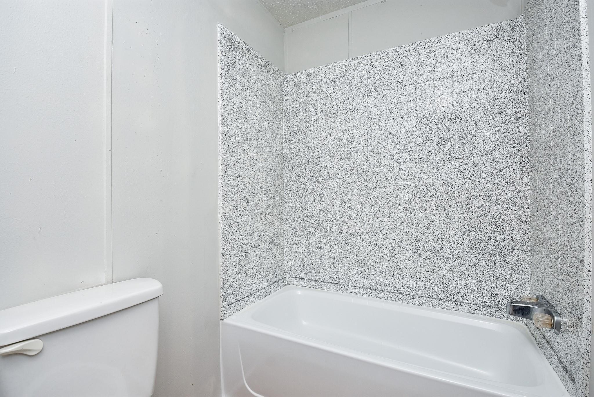 12842 Roy Harris Loop Conroe, TX 77306 - Photo 32 of 36 a white bath tub sitting next to a white toilet