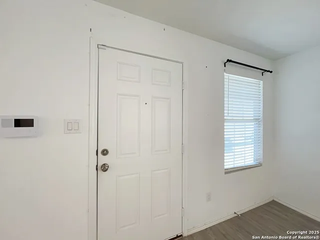 a view of an empty room with closet and a window