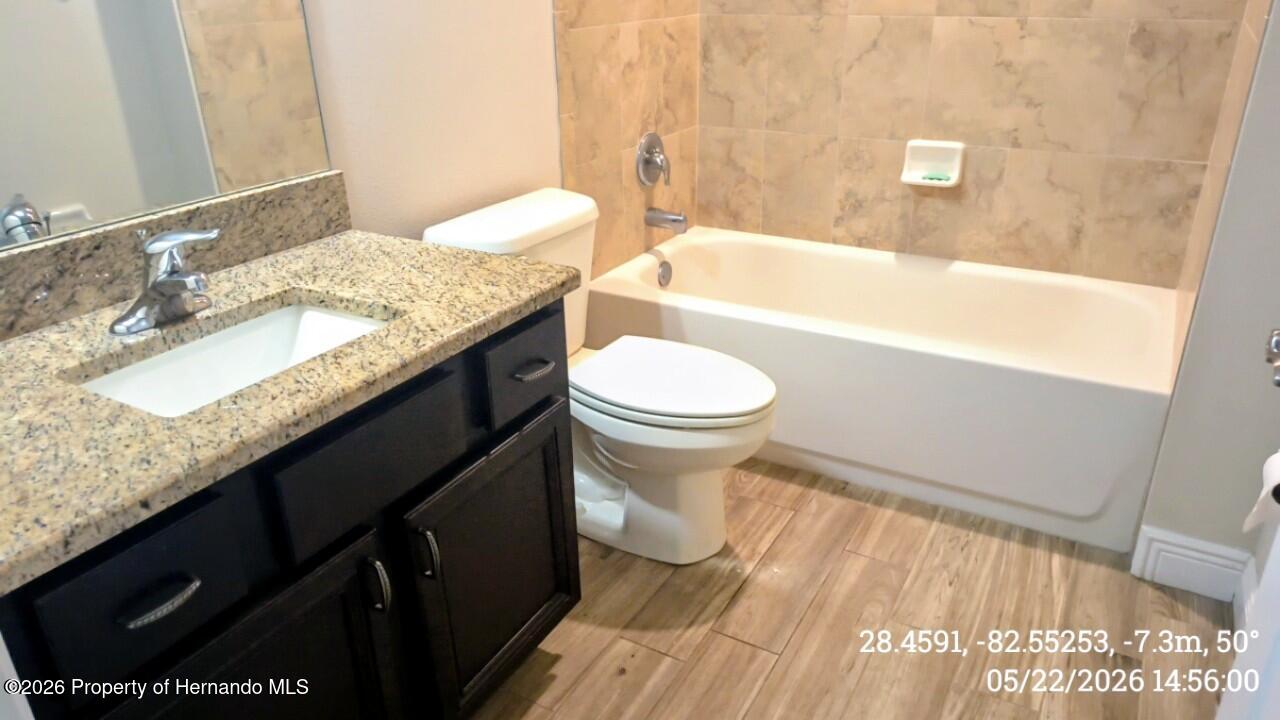 10244 Heathcliff Street Spring Hill, FL 34608 - Photo 20 of 30 a bathroom with a granite countertop sink toilet and bathtub