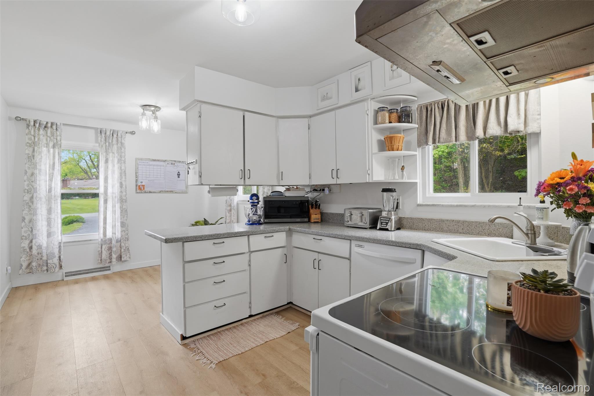 47129 Dunsany Road Northville, MI 48167 - Photo 12 of 49 Kitchen with white appliances, white cabinets, light wood-type flooring, and plenty of natural light
