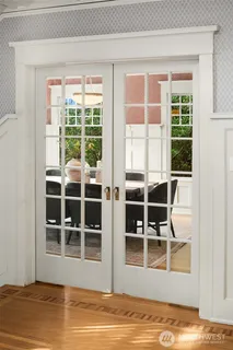 a view of empty room with wooden floor and windows