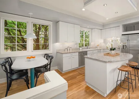 a kitchen with a stove a sink a dining table and chairs