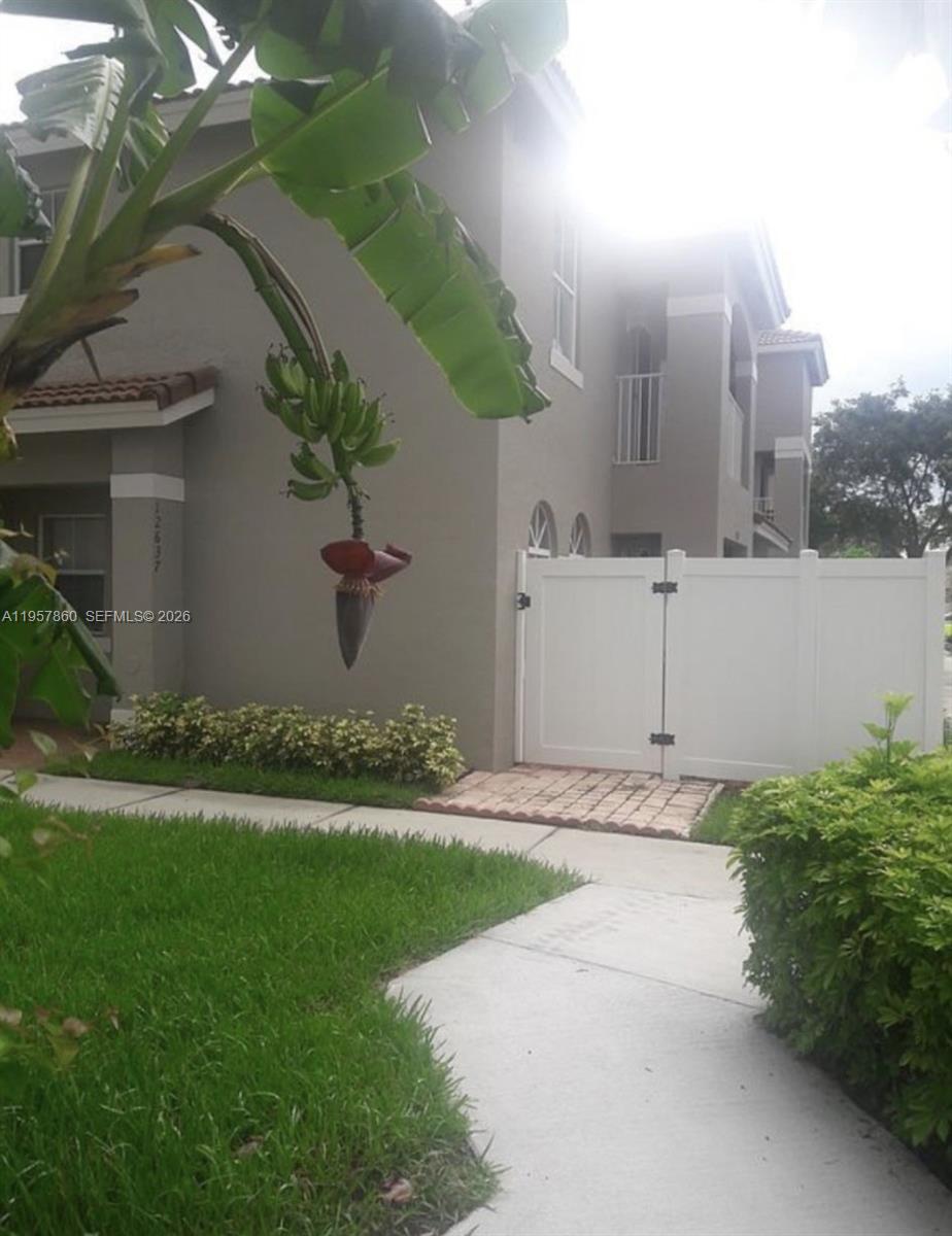 12637 Southwest 54th Street Miramar, FL 33027 - Photo 4 of 16 a front view of a house with garden