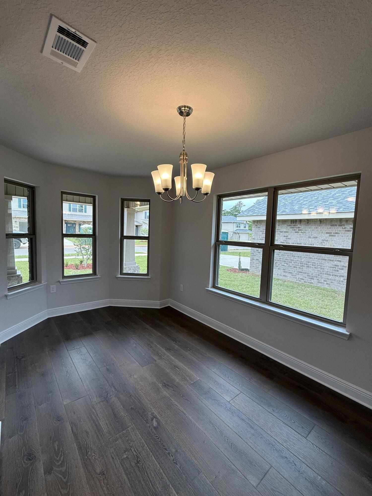 192 Ridgeway Circle Crestview, FL 32536 - Photo 5 of 18 an empty room with wooden floor and windows