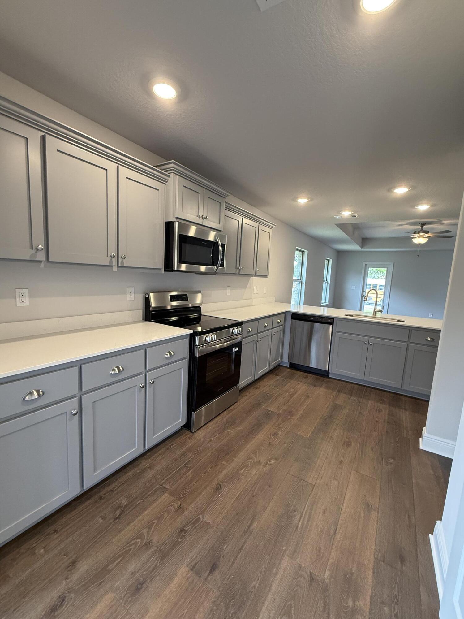 192 Ridgeway Circle Crestview, FL 32536 - Photo 7 of 18 a large kitchen with stainless steel appliances granite countertop a stove a sink dishwasher and a microwave oven on the wooden floor