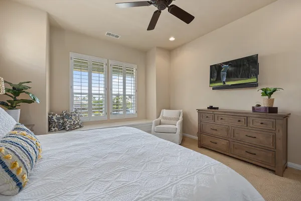 a bedroom with a large bed and a flat screen tv