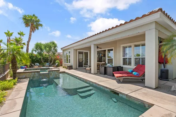 a view of a house with pool and chairs