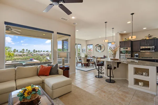 a kitchen with kitchen island granite countertop a table chairs microwave and cabinets