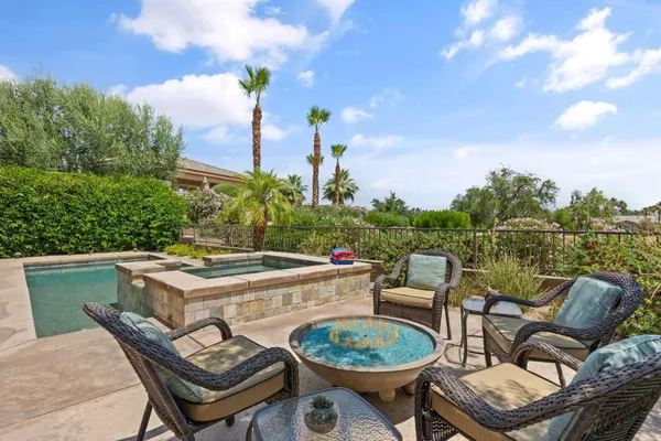 a view of a patio with dining table and chairs with wooden fence