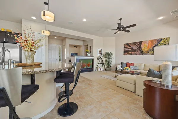 a kitchen with stainless steel appliances granite countertop a sink a stove a refrigerator and a dining table with wooden floor