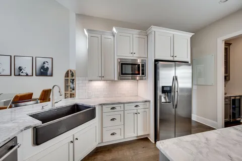 a kitchen with white cabinets and stainless steel appliances