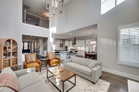 a living room with furniture a chandelier and a window