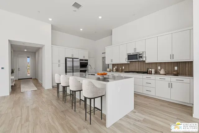 a large white kitchen with stainless steel appliances