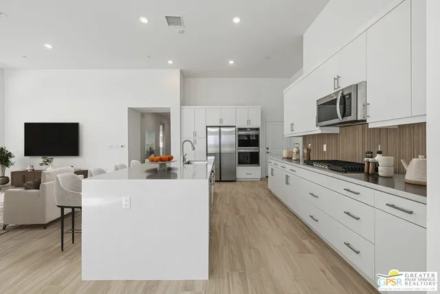 a kitchen with granite countertop white cabinets and stainless steel appliances