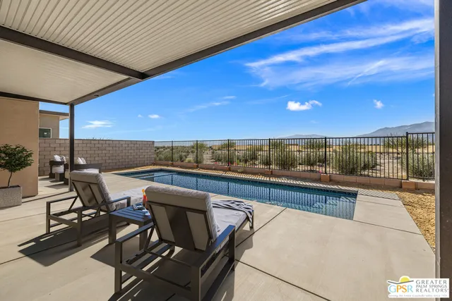 a view of a swimming pool with outdoor seating and plants