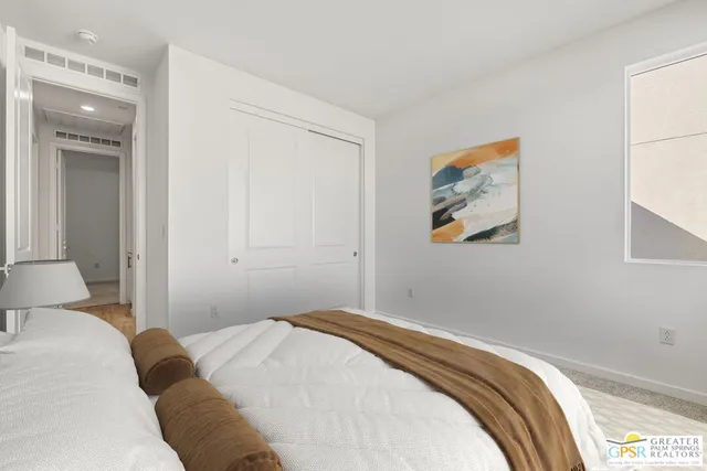 a bedroom with a bed and a painting on the wall