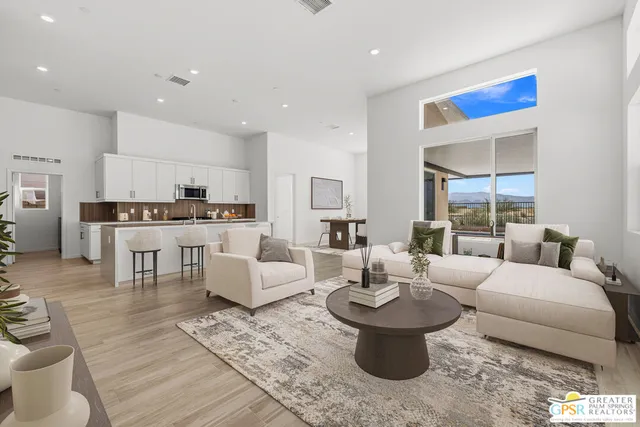 a living room with furniture and view of kitchen
