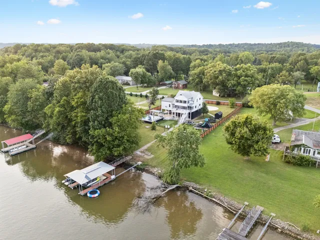 an aerial view of a house with a garden and lake view