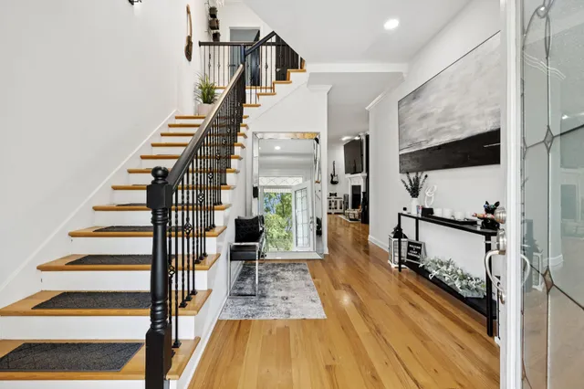 a view of staircase and living room with wooden floor