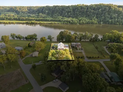 an aerial view of a house with a garden and lake view