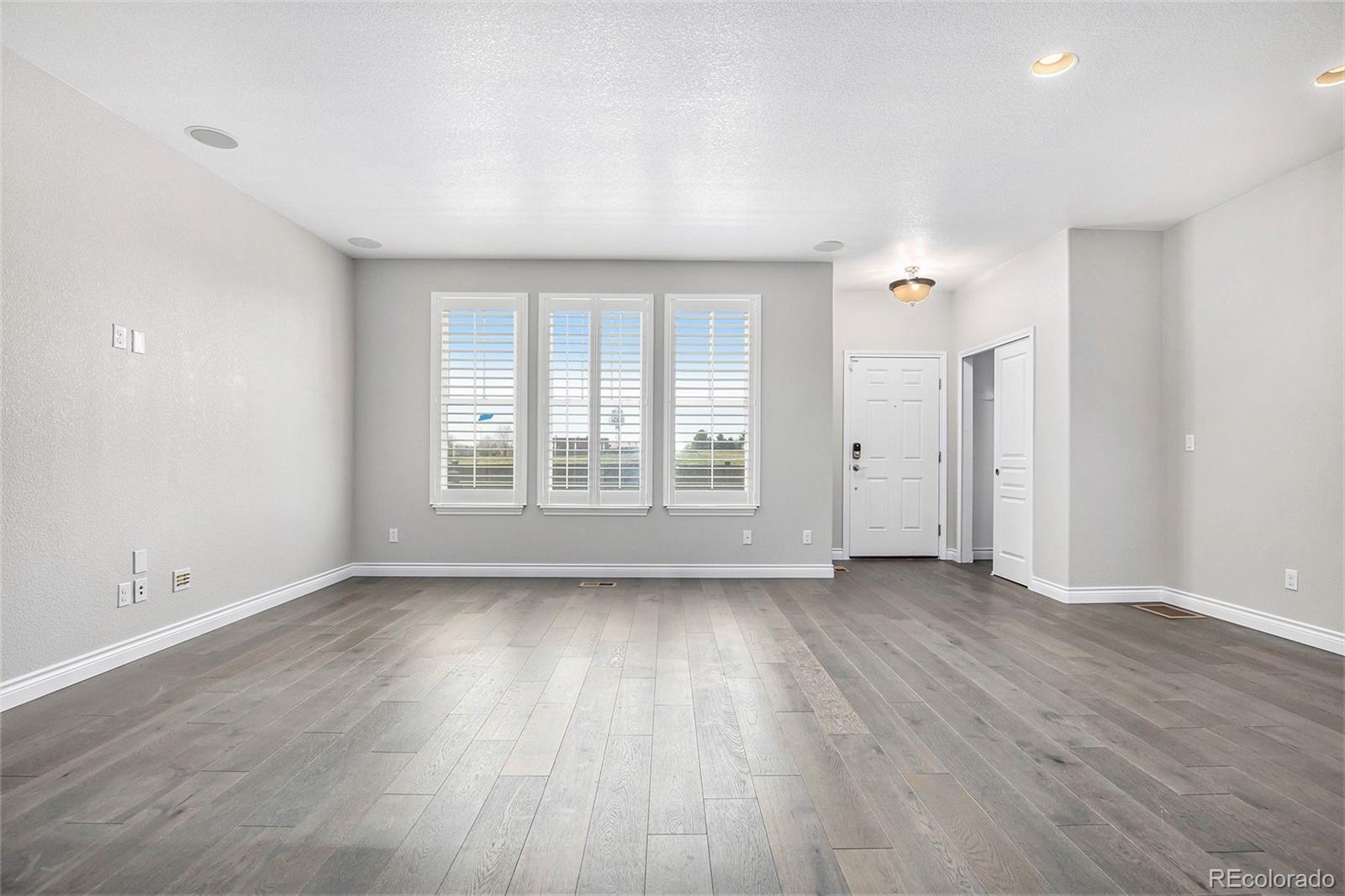 3751 West 136th Avenue, Unit C3 Broomfield, CO 80023 - Photo 11 of 20 an empty room with wooden floor and windows