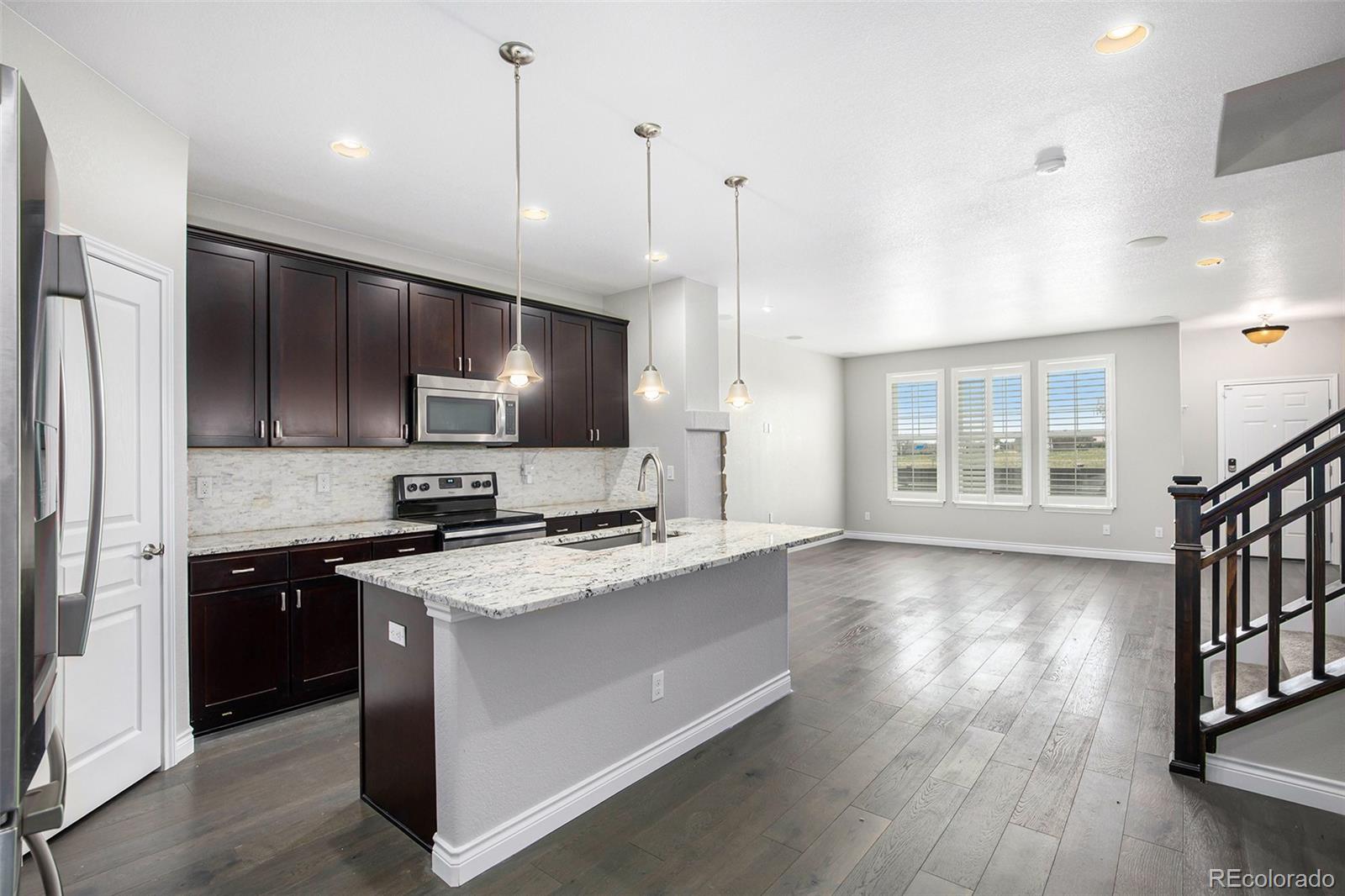 3751 West 136th Avenue, Unit C3 Broomfield, CO 80023 - Photo 8 of 20 a kitchen with stainless steel appliances kitchen island a cabinets and a wooden floor