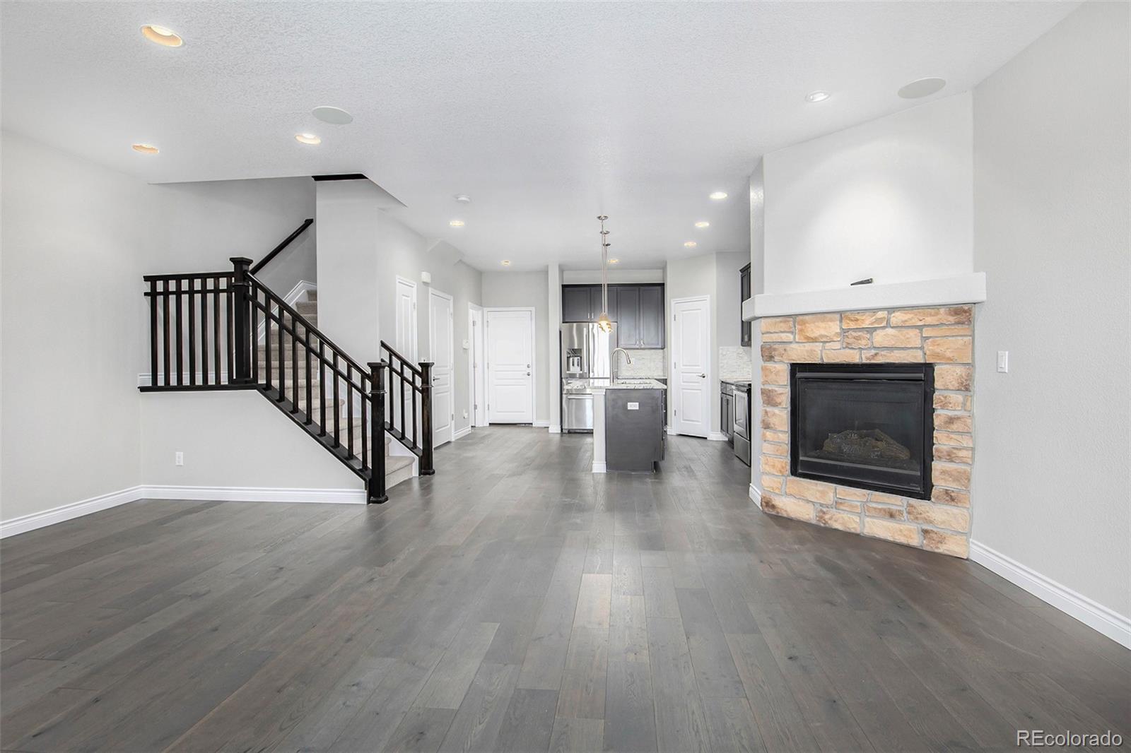 3751 West 136th Avenue, Unit C3 Broomfield, CO 80023 - Photo 10 of 20 an empty room with wooden floor fireplace and windows