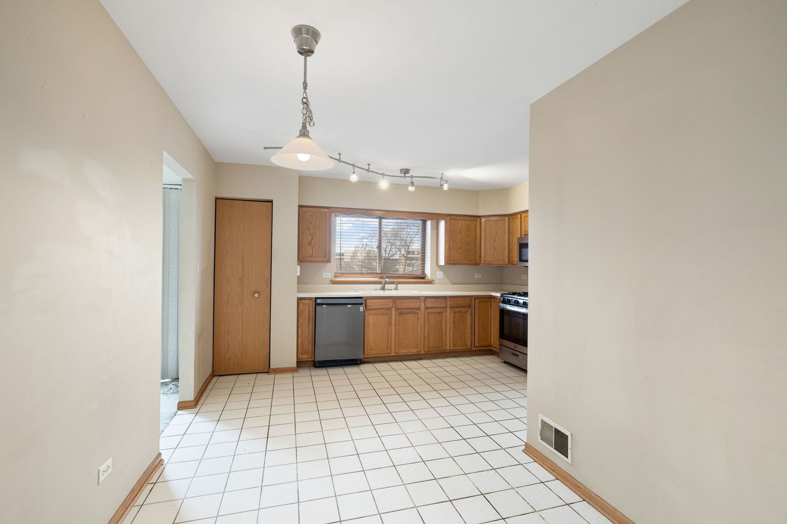 18112 Rita Road, Unit 3C Tinley Park, IL 60477 - Photo 6 of 18 a large kitchen with a sink stainless steel appliances and cabinets