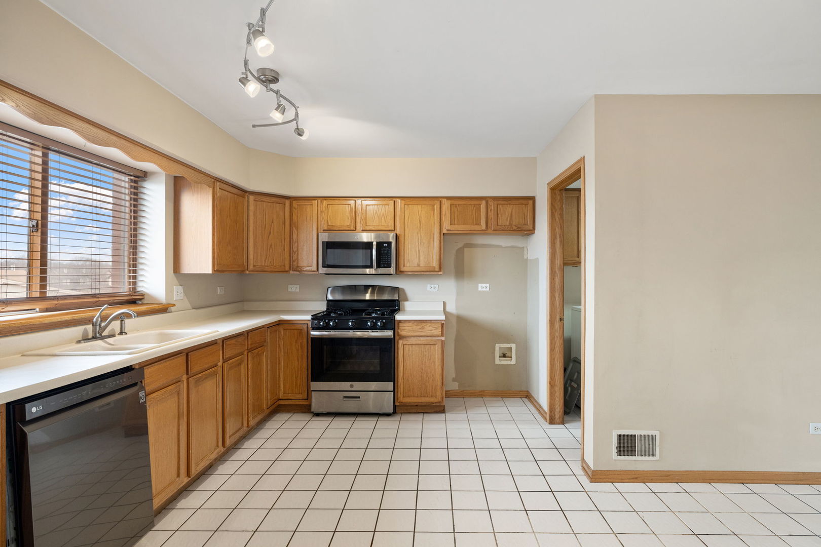 18112 Rita Road, Unit 3C Tinley Park, IL 60477 - Photo 7 of 18 a large kitchen with stainless steel appliances a sink stove refrigerator and cabinets