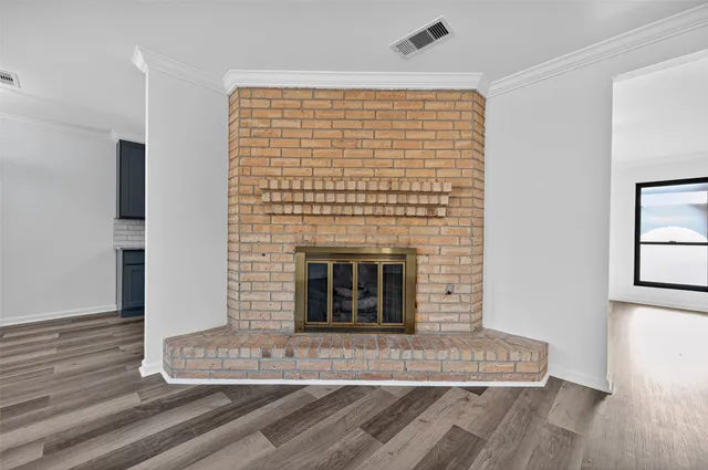 a living room with a fireplace and wooden floor