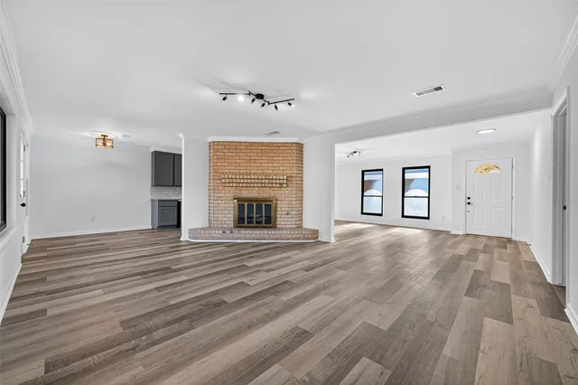a view of empty room with wooden floor and fireplace