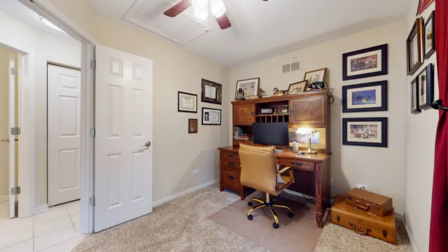 a view of a workspace with furniture and a window