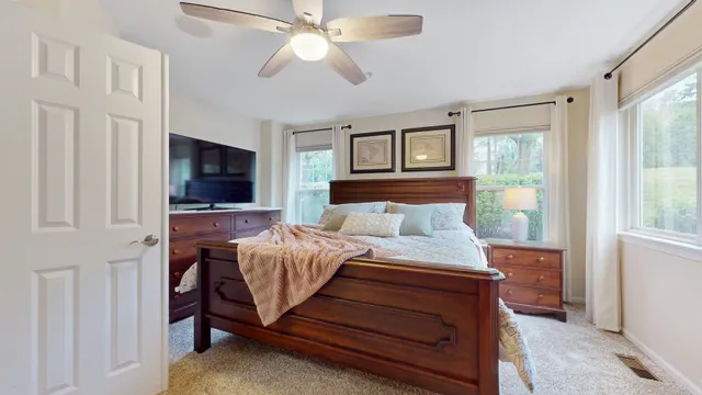 a bed room with a bed tv and a window