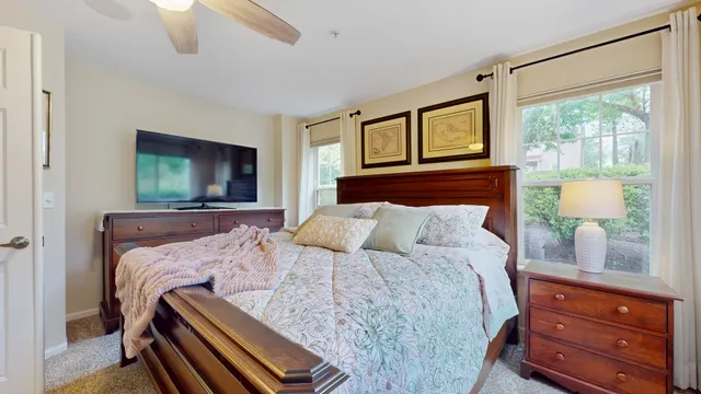 a bedroom with a bed and a flat tv screen on dresser