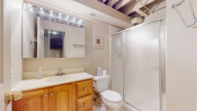 a bathroom with a sink a toilet a mirror and shower
