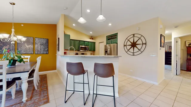 a view of kitchen with stainless steel appliances granite countertop living room and chair