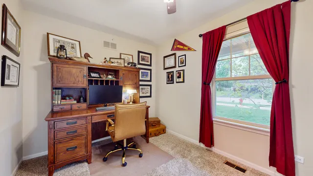 a view of a workspace with furniture and a window