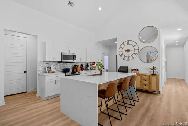 a kitchen with a table chairs and a stove top oven with wooden floor